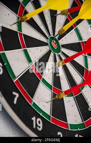 Datboard und einige bunte Darts für weniger Zeit auf verwendet Ein weißer Tisch Stockfoto