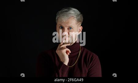 Mann, der sich am Kinn reibt, über die Idee nachdenkt, sich einen Plan im Kopf vorstellt, Zweifel an der Antwort hat, wählt euch aus Stockfoto