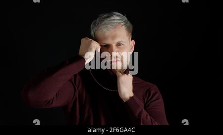 Stilvoller Mann mit blauen Augen in trendigen Kleidern, der die Kamera anschaut, Glück, Spaß und Freude fühlt Stockfoto