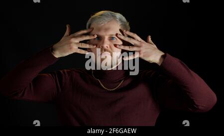 Stilvoller junger Mann mit blauen Augen, der die Kamera anschaut, posiert, Glück fühlt, Spaß macht, Freude macht Stockfoto