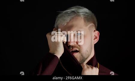 Stilvoller Mann mit blauen Augen in trendigen Kleidern, der die Kamera anschaut, Glück, Spaß und Freude fühlt Stockfoto