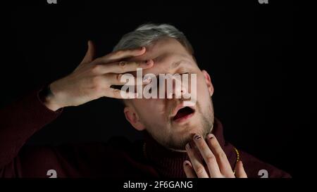 Stilvoller junger Mann mit blauen Augen, der die Kamera anschaut, posiert, Glück fühlt, Spaß macht, Freude macht Stockfoto