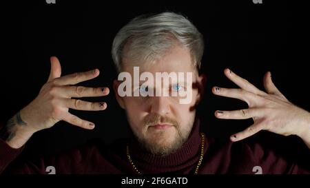 Stilvoller junger Mann mit blauen Augen, der die Kamera anschaut, posiert, Glück fühlt, Spaß macht, Freude macht Stockfoto