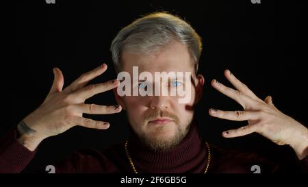 Stilvoller junger Mann mit blauen Augen, der die Kamera anschaut, posiert, Glück fühlt, Spaß macht, Freude macht Stockfoto