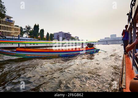 Traditionelles Long Tail Thailand Boot mit Touristen, die am Nachmittag entlang des Chao Phraya Flusses fahren, umgeben vom Hintergrund von Bangkok, Tha Stockfoto