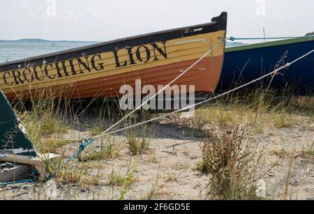 Viele farbenfrohe Skiffs säumen die Küste von Hull, Massachusetts. In der Nähe im Hafen befinden sich die Boston Harbor Islands. Ein Fährschiff transportiert Passagiere Stockfoto