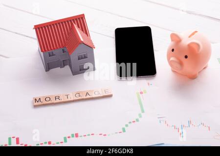 Sparschwein, Telefon und Haus auf Hypothekenhoroskop und Titel Hypothek Stockfoto