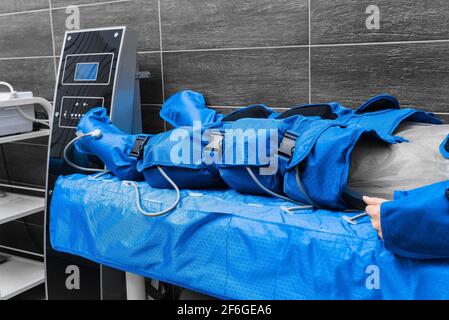 Beine des Patienten in einem Anzug der Pressotherapie und Lymphdrainage-Massage. Stockfoto