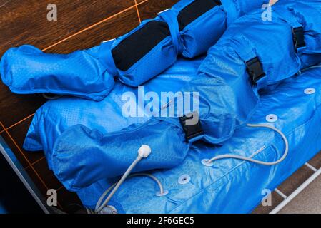 Nahaufnahme der Beine des Patienten im Massageanzug für Pressotherapie und Lymphdrainage. Stockfoto
