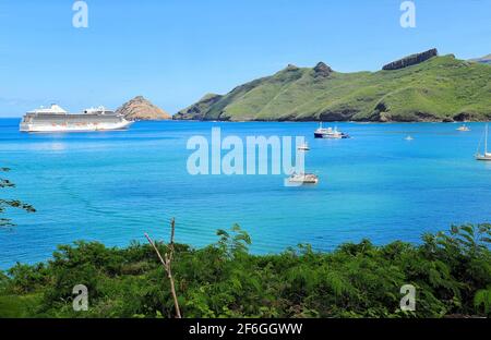 Ein auf den polynesischen Inseln fahrende Kreuzschiff liegt in den erwärmt Gewässern des Pazifischen Ozeans nahe einer Insel Französisch-Polynesien vor Anker. Stockfoto