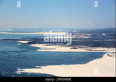 Blick südlich von Thunder Bay aus der Luft an einem sonnigen Tag mit blauem Himmel, bei dem noch Spätschnee und Eis schmelzen, auf den Lake Superior. Stockfoto