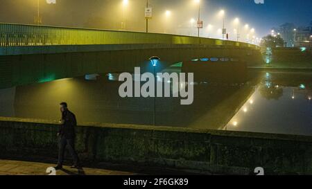 Nachtnebel über der Debnicki-Brücke über die Weichsel, Krakau, Polen, mit der Perspektive von beleuchteten Straßenlaternen Stockfoto