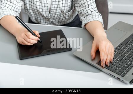 Frau Kreative Designerin, die mit professioneller Ausrüstung arbeitet. Freelancer setzt auf Grafikkarten. Designerin oder Fotografin verwenden Grafiken Stockfoto