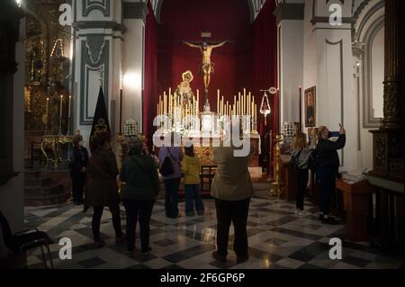 Malaga, Spanien. März 2021. Gläubige, die in der Kirche von Santiago Christus sehen, als Teil der Verehrung während der Karwoche.Trotz der Absage der Karwoche haben sich viele Bruderschaften entschieden, nach allen Schutzmaßnahmen gegen Covid19, Messen, Verehrung und die Ausstellung von Figuren von Christus und der Jungfrau, mit denen sie heiraten, in den Kirchen zu organisieren. (Foto von Jesus Merida/SOPA Images/Sipa USA) Quelle: SIPA USA/Alamy Live News Stockfoto