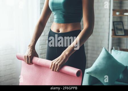 Fit kaukasische Frau trägt Sportkleidung beim Sammeln des Yoga Mat Stockfoto