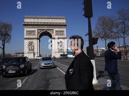 Paris, Frankreich. März 2021. People Walk in der Nähe des Triumphbogens in Paris, Frankreich, 31. März 2021. Um die Ausbreitung des Coronavirus zu verlangsamen und den Weg für eine allmähliche Rückkehr zur Normalität bis Mitte Mai zu ebnen, werden die Schulen in Frankreich für drei Wochen geschlossen und die in vielen Regionen bereits in Kraft getretenen Einschränkungen der Volksbewegung auf das gesamte Gebiet ausgeweitet. Präsident Emmanuel Macron kündigte am Mittwochabend an. Kredit: Gao Jing/Xinhua/Alamy Live Nachrichten Stockfoto