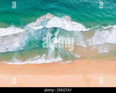 Luftaufnahme von oben schöner topischer Strand mit weißem Sand Kokospalmen und Meer. Blick von oben leerer und sauberer Strand. Wellen krachen leer Strand Fr. Stockfoto