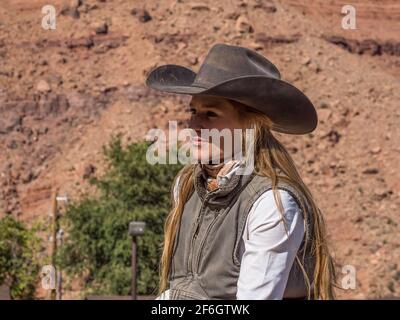 Eine junge attraktive, arbeitende Cowgirl-Wranglerin auf ihrem Pferd auf einer Ranch in der Nähe von Moab, Utah. Stockfoto