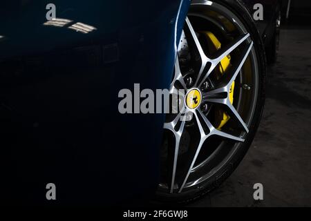 Das Vorderrad Diamond Cut Wheel auf EINEM Metallic Blue 2016 Ferrari California T mit gelben Bremssättel Stockfoto