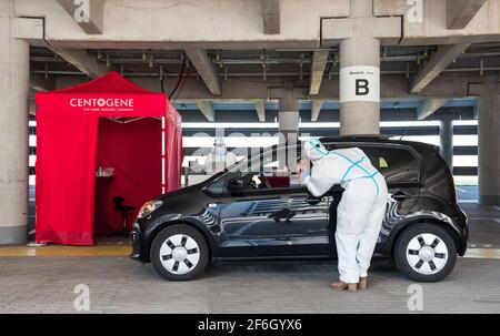 Hamburg, Deutschland. März 2021. Ein Mitarbeiter nimmt an einem Corona-Test während eines Probelaufens für ein Drive-Through-Corona-Testzentrum am Flughafen statt. Ab heute bietet eine Parkgarage am Flughafen die Möglichkeit, sich auf das Corona-Virus in Ihrem Auto testen zu lassen. Quelle: Daniel Bockwoldt/dpa/Alamy Live News Stockfoto