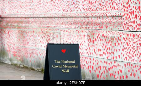 London, Großbritannien. März 2021. Das am 31. März 2021 aufgenommene Foto zeigt die National COVID Memorial Wall in London, Großbritannien. Trauerliche Familienmitglieder und Freiwillige sind dabei, Herzen entlang einer halben Meile Mauer gegenüber dem Houses of Parliament in London zu malen, um an diejenigen zu erinnern, die an COVID-19 gestorben sind. Weitere 4,052 Menschen in Großbritannien testeten COVID-19 positiv, was die Gesamtzahl der Coronavirus-Fälle im Land auf 4,345,788 brachte, laut offiziellen Zahlen, die am Mittwoch veröffentlicht wurden. Quelle: Han Yan/Xinhua/Alamy Live News