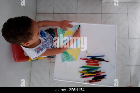 salvador, bahia / brasilien - 18. november 2020: Das Kind wird während der Schulaktivitäten eine Zeichnung der brasilianischen Flagge malen sehen. Stockfoto