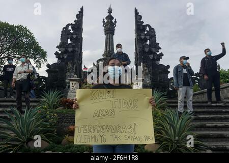 Denpasar, Bali, Indonesien. März 2021. Studenten überbringen Protestplakate am Bajra Sandhi Monument. Studenten von Universitäten in Bali veranstalteten am 28. März eine Kundgebung als Akt gegen den Selbstmordanschlag vor der Kathedrale von Sacred Heart of Jesus in Makassar, Süd-Sulawesi, bei der 9 Menschen verletzt wurden. Kredit: Dicky Bisinglasi/ZUMA Wire/Alamy Live Nachrichten Stockfoto