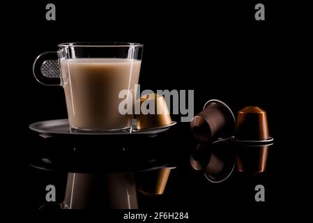 Tasse Kaffee. Glas Espresso Tasse mit Kapseln auf dunklem Hintergrund . Stockfoto