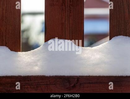 Ländliche Holzzaun bedeckt mit frisch gefallenen Schnee. Stockfoto