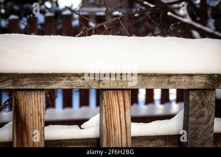 Ländliche Holzzaun bedeckt mit frisch gefallenen Schnee. Stockfoto