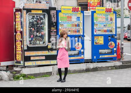 Pretty promo girl leafletting vor Automaten, Ikebukuro, Tokio, Japan Stockfoto