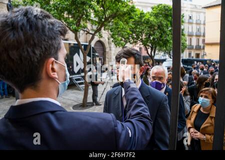 Malaga, Spanien. März 2021. Ein Mann misst die Temperatur von Menschen, die an dem Befreiungsakt von drei Gefangenen teilnehmen. Die Bruderschaft El Rico lässt seit 1759 jedes Jahr einen Gefangenen frei. König Carlos III. Gewährte dieser Bruderschaft dieses Privileg. Es ist das erste Mal in der Geschichte, dass die Bruderschaft von El Rico drei Gefangene freilässt. Sie lassen in der Regel nur einen Gefangenen frei. Zwei von ihnen begingen Straftaten im Bereich des Drogenhandels. Auf der anderen Seite ist Raub mit Gewalt das Verbrechen, für das der andere Gefangene verurteilt wurde. Kredit: SOPA Images Limited/Alamy Live Nachrichten Stockfoto