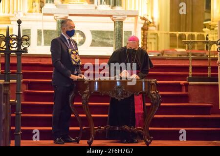 Malaga, Spanien. März 2021. Der Bischof von Málaga, Jesus Catala (R), und der Präsident der Bruderschaft El Rico unterzeichnen die Begnadigungsurkunde von drei Gefangenen. Die Bruderschaft El Rico lässt seit 1759 jedes Jahr einen Gefangenen frei. König Carlos III. Gewährte dieser Bruderschaft dieses Privileg. Es ist das erste Mal in der Geschichte, dass die Bruderschaft von El Rico drei Gefangene freilässt. Sie lassen in der Regel nur einen Gefangenen frei. Zwei von ihnen begingen Straftaten im Bereich des Drogenhandels. Auf der anderen Seite ist Raub mit Gewalt das Verbrechen, für das der andere Gefangene verurteilt wurde. Kredit: SOPA Images Limited/Alamy Live Nachrichten Stockfoto