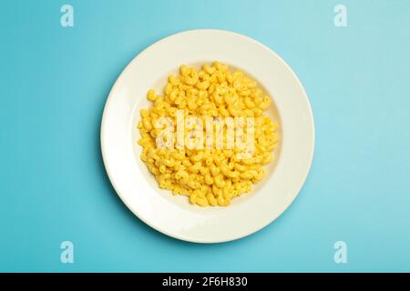 Pasta-Hintergrund. Nudeln mit Mac und Käse auf blauem Hintergrund. Italienische Pasta im amerikanischen Stil mit Käse. Hochwertige Fotos Stockfoto