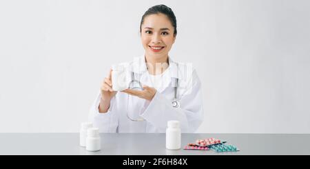 Asiatische junge schöne weibliche Arzt Lächeln und zeigen die Medizin Flasche in der Hand im Krankenhaus Stockfoto