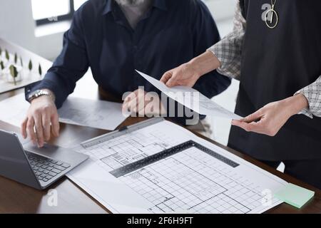 Nahaufnahme von Architekten, die gemeinsam Pläne untersuchen und ein neues Projekt entwickeln Im Büro Stockfoto