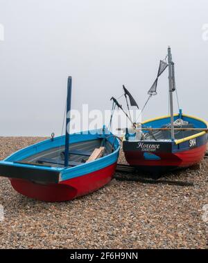 Zwei kleine Fischerboote an einem Kiesstrand an der Südküste von England, Großbritannien. Stockfoto