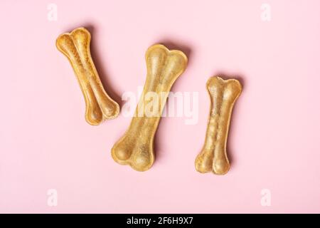 Knochen für Hunde isoliert auf rosa Hintergrund Draufsicht Flat Lay Delicious Treat für Ihr geliebtes Haustier Food for Animals Konzept. Stockfoto