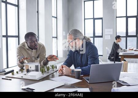 Zwei Architekten sitzen am Tisch mit Modell der neuen Aufbau und Diskussion eines neuen Projekts im Büro Stockfoto