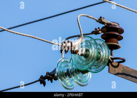 Elektrischer Pol gegen den blauen klaren Himmel. Dreiphasige Stromleitung zum Drehen. Stockfoto