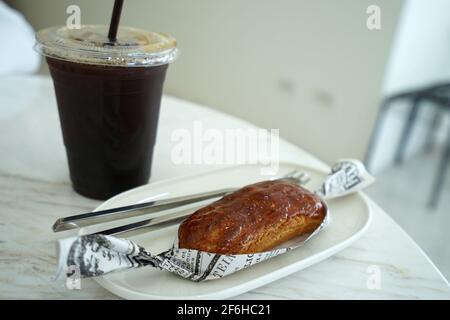 Nahaufnahme Caramellow eclair (Creme- und Karamellkuchen) Serviert mit Eiskaffee Stockfoto