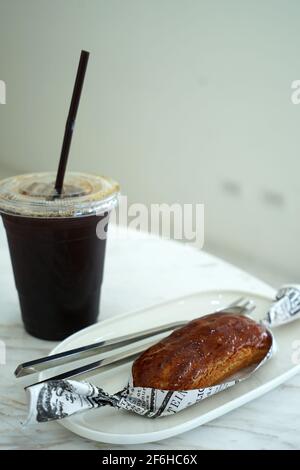 Nahaufnahme Caramellow eclair (Creme- und Karamellkuchen) Serviert mit Eiskaffee Stockfoto