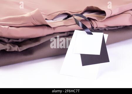 Makro-Modell leeres Papier schwarz-weiß-Etikett oder Auf einem Stapel T-Shirts oder Hoodies kennzeichnen Stockfoto