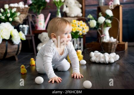 Niedliches Kleinkind blondes Kind, Junge mit osterdekoration im Studio, kriechen auf dem Boden Stockfoto