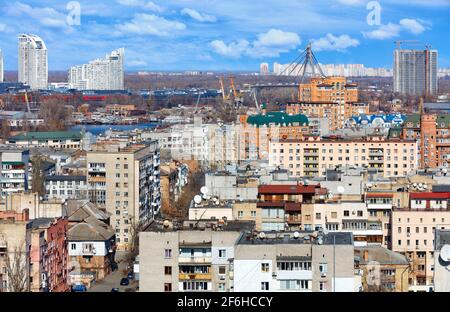 Das Stadtbild der Straßen des alten Podil in Kiew vor dem Hintergrund neuer Wohngebäude im Bau am Horizont. Stockfoto