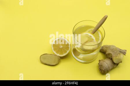 Winter kalt kur Infusion von Zitrone und frischem Ingwer auf Gelber Hintergrund Stockfoto