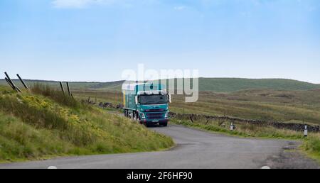 I'anson-Wagen mit Viehfutter, der auf einer schmalen Landstraße in North Yorkshire, Großbritannien, unterwegs ist. Stockfoto