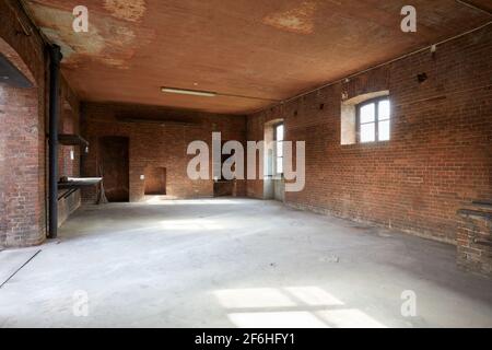 Altes, leeres Werkstattinterieur mit roten Ziegelwänden, Sonnenlicht Stockfoto