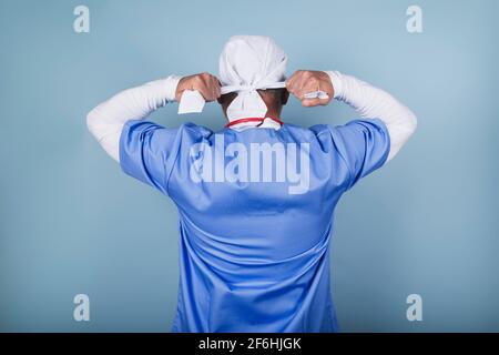 Arzt bindet die OP-Kappe Stockfoto