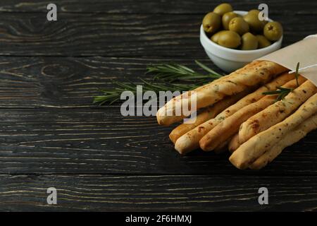 Bastelpapier mit Grissini, Oliven und Rosmarin auf Holzgrund Stockfoto